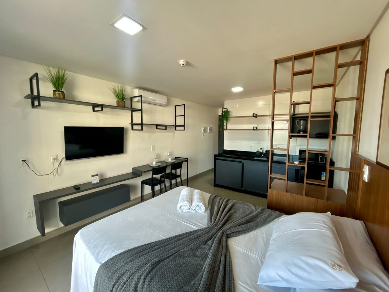 Flat 302 com TV, bancada de refeição e cozinha compacta equipada