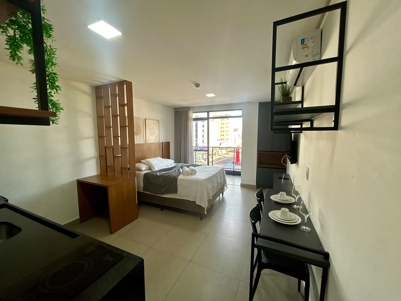 Vista do flat 302 a partir da entrada, com divisória de madeira e acesso à varanda